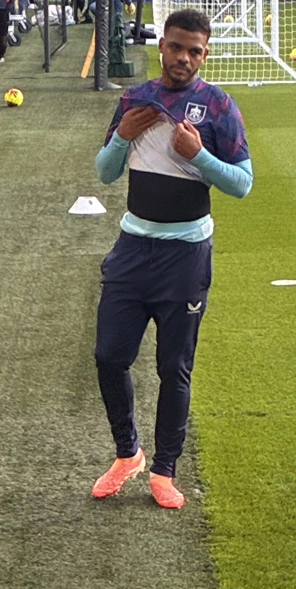 Lyle Foster warming up in Burnley kit beside the pitch.