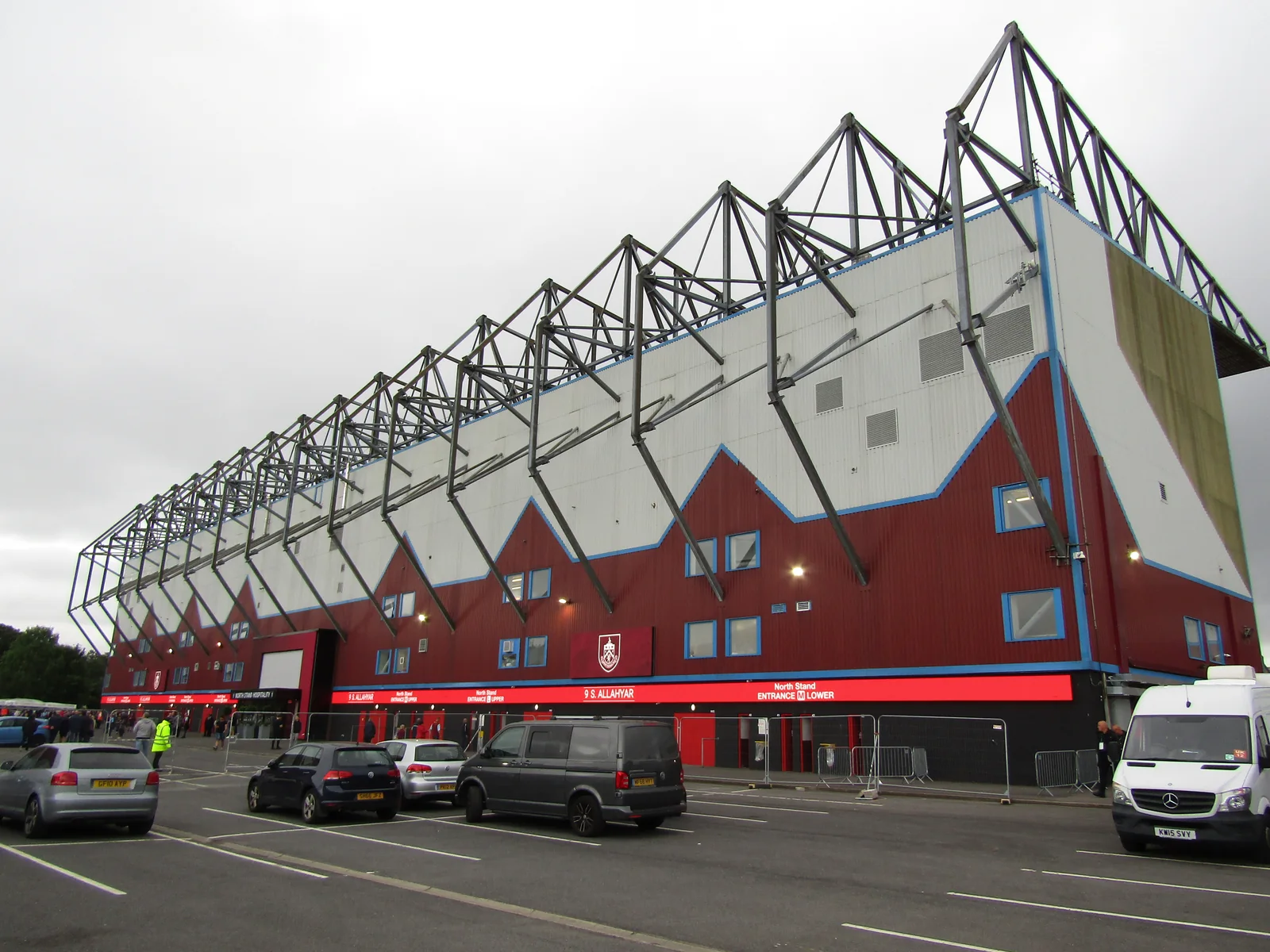 The claret, blue and white exterior of Turf Moor with its repeating black steel roof supports.